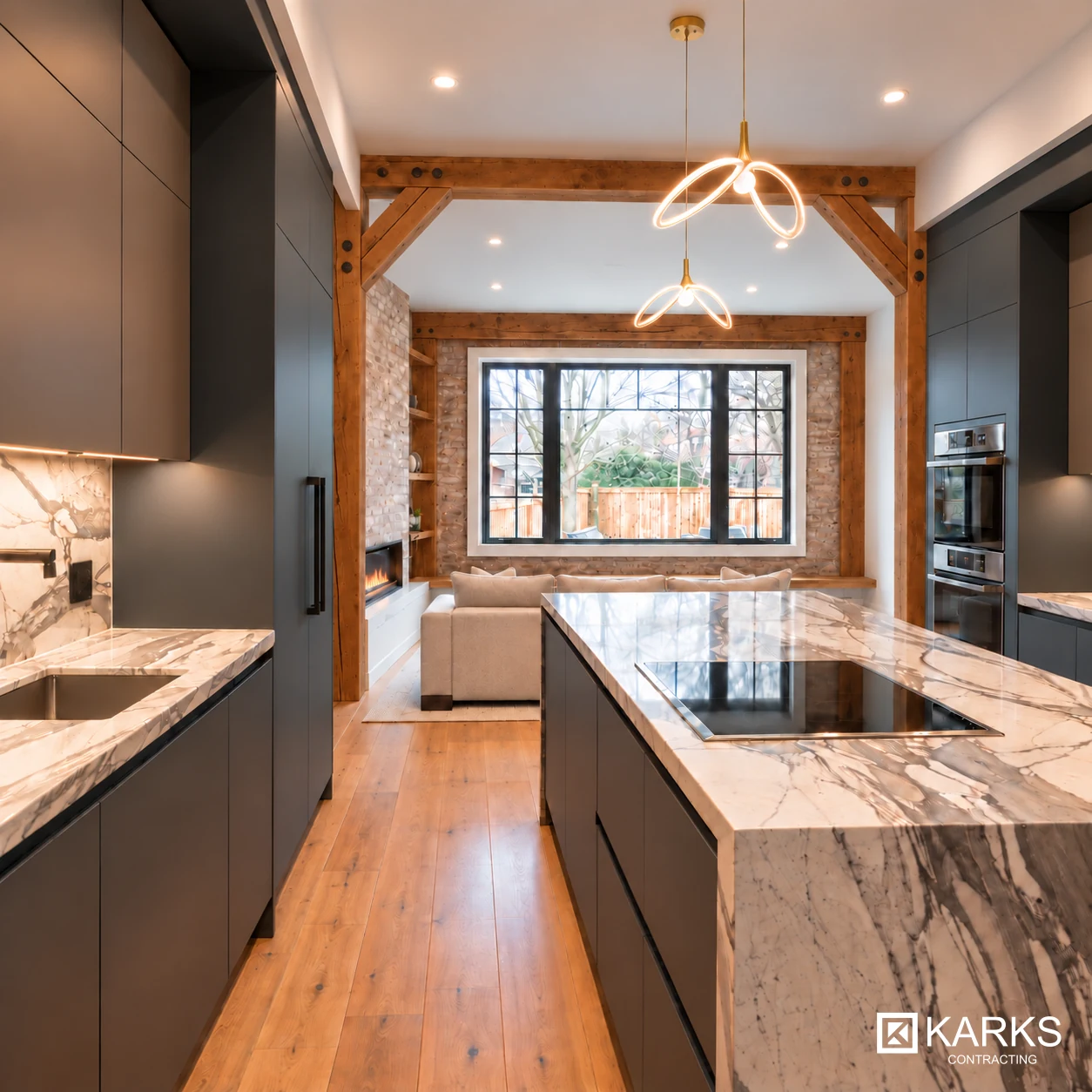 Second view of the completed kitchen with dark cabinets, stone island and an opening to the living room