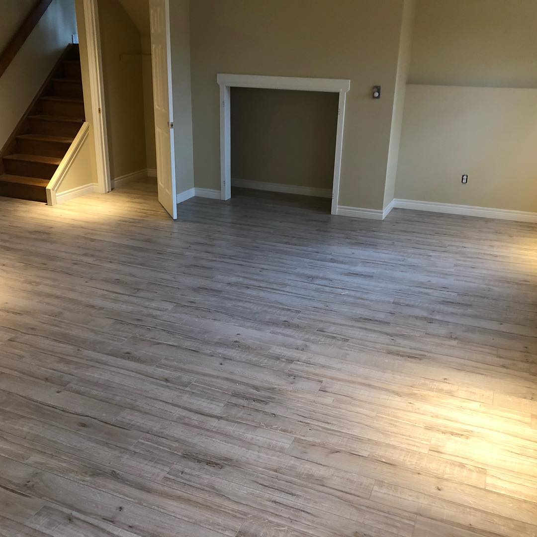 Open basement living area with new flooring and refreshed interior finishes